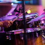 Close up hands of a musician playing drum set in a concert. Motion image.